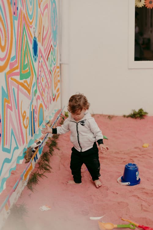 Criança explorando um muro colorido