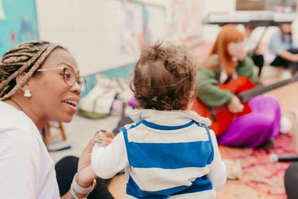 Educadora conversando de perto com um bebê