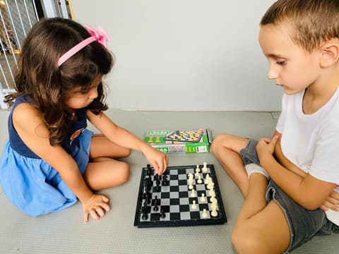 Crianças conversando e jogando xadrez juntas